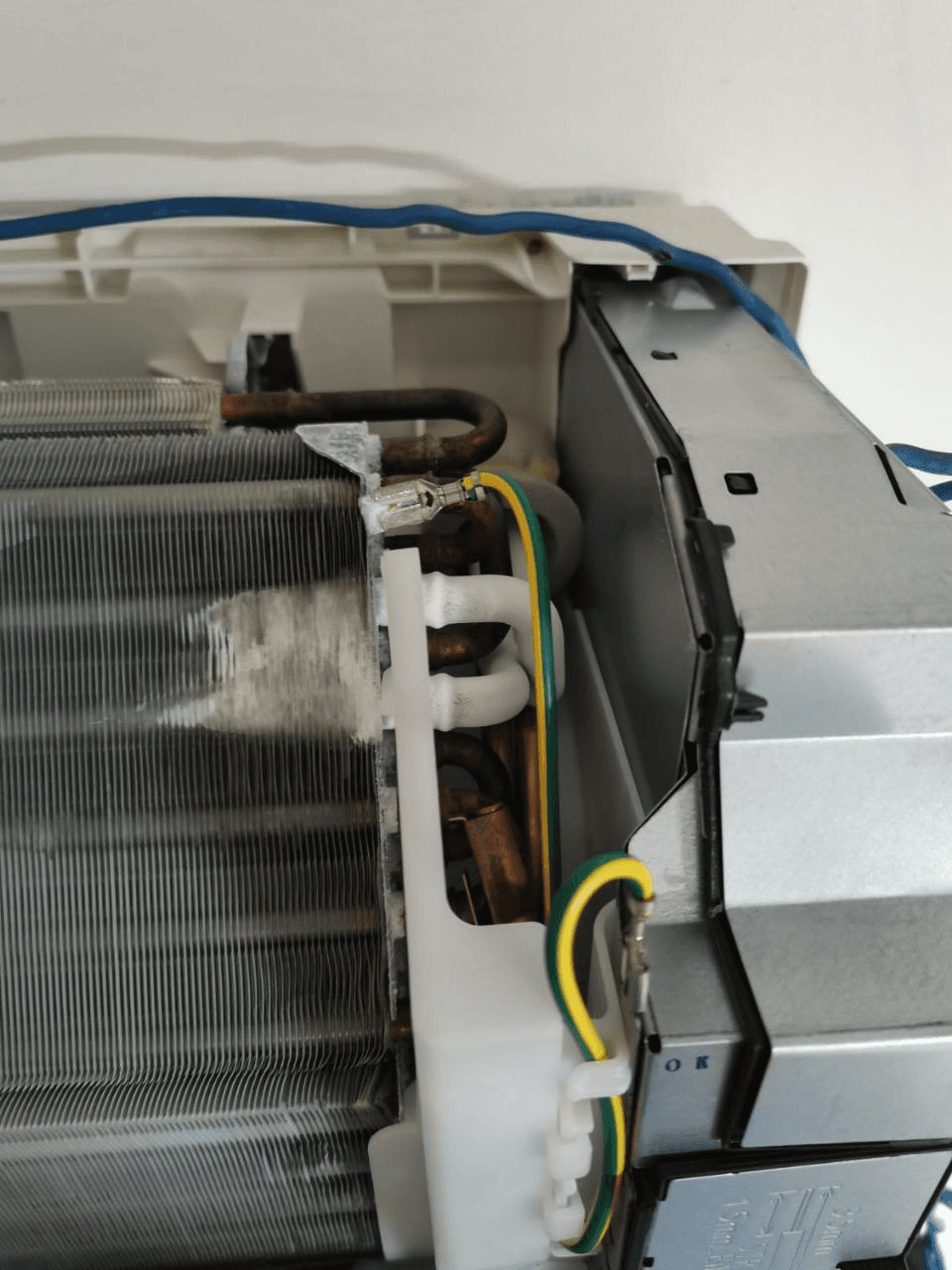 Ice buildup on copper refrigerant pipes inside wall-mounted indoor unit with cover removed