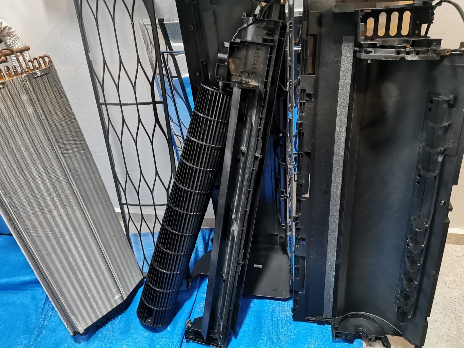 Wall-mounted aircon unit stripped and disassembled for chemical overhaul