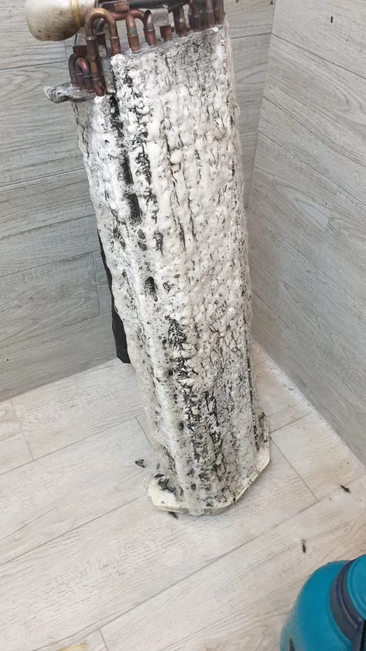 Wall-mounted unit opened with blower housing and motor exposed for inspection