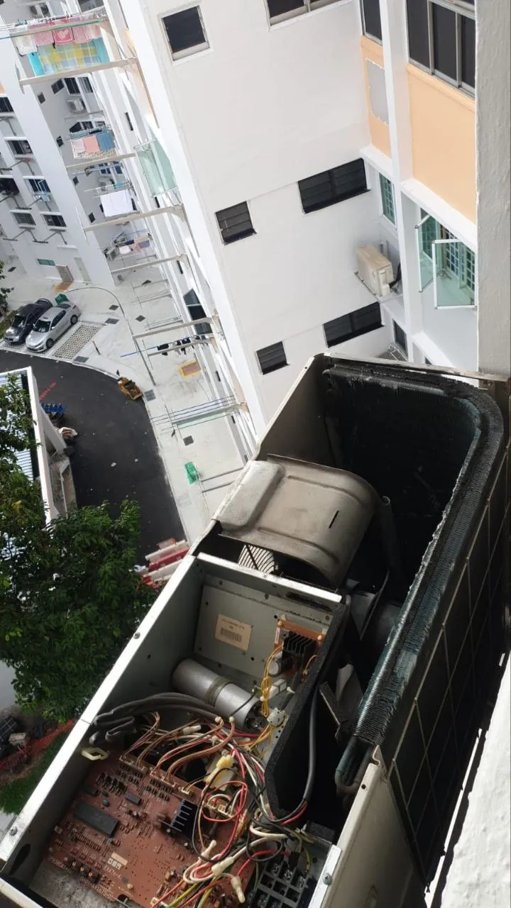 Outdoor condenser unit internals inspected on high-floor condo ledge