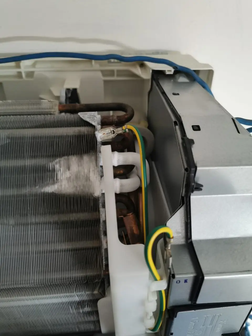 Ice buildup on copper refrigerant pipes inside wall-mounted indoor unit with cover removed