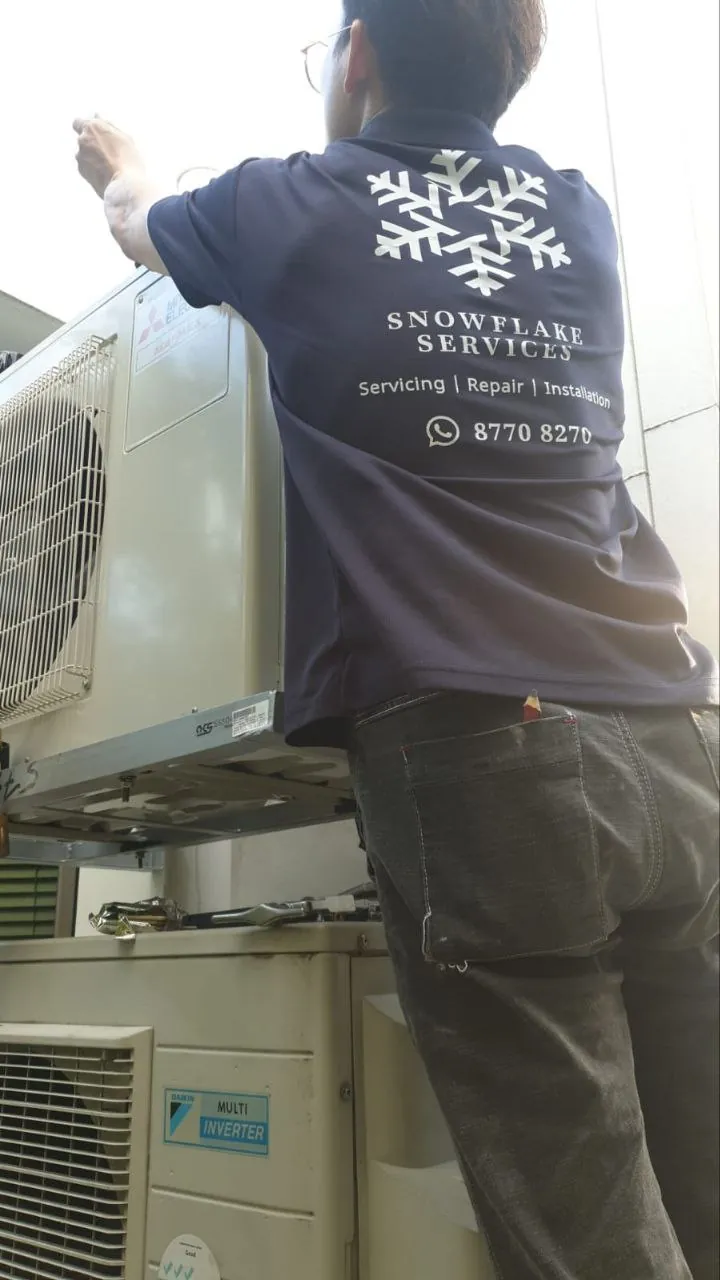 Technician working on an outdoor condenser unit