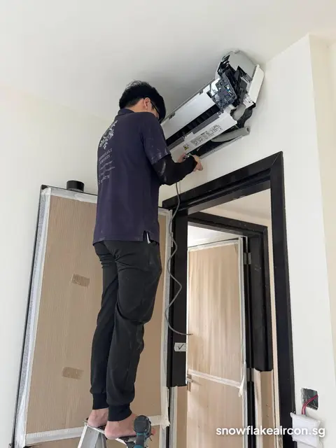 Technician tilting a wall unit off its bracket