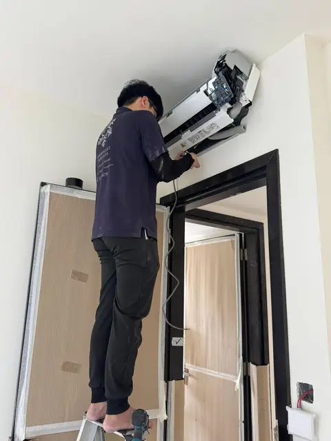 Technician tilting a wall unit off its bracket
