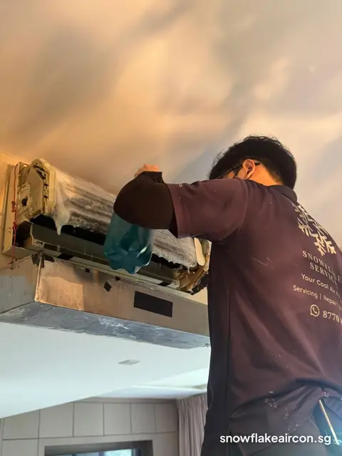 Technician with cover sheet on a ceiling-mounted unit